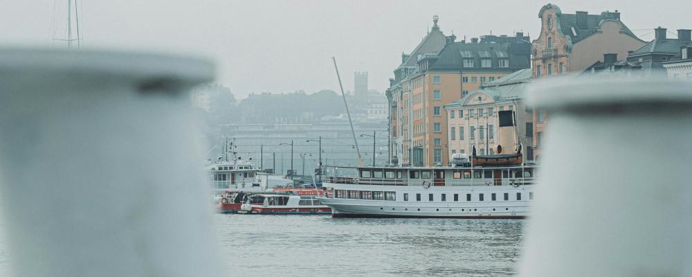 Skeppsbron i Stockholm, sett från vattnet med Gamla stan i bakgrunden. Foto: Magnus Andersson/Unsplash