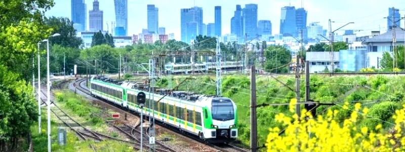 FLIRT-tåg från Stadler på väg i Warszawas omgivningar. I bakgrunden syns den polska huvudstaden skyline. Foto: Stadler