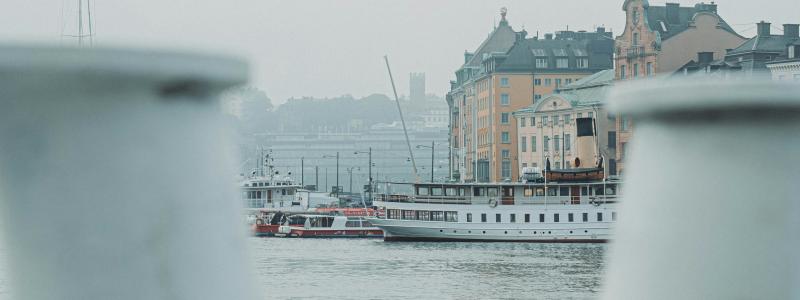Skeppsbron i Stockholm, sett från vattnet med Gamla stan i bakgrunden. Foto: Magnus Andersson/Unsplash