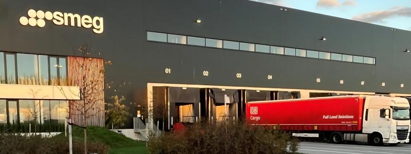 Utanför Smegs lager syns DB Cargo Full Load Solutions röda trailer rulla in med gods för lossning. Godset transporteras via DB Cargo Full Load Solutions intermodala transportlinje mellan Sverige och Italien. Foto: DB Cargo