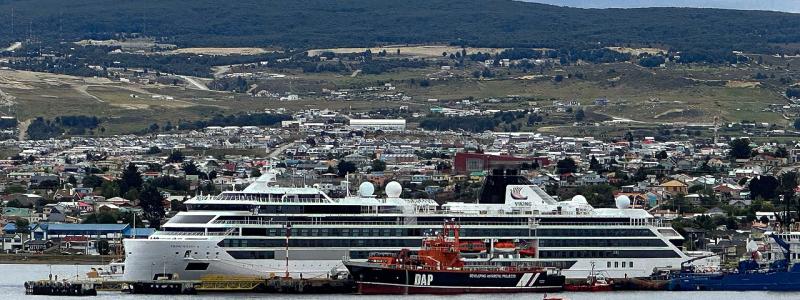 Viking Polaris ligger i hamnen i Chile för reparation efter att ha drabbats av en jättevåg ungefär tio dagar tidigare. Bilden togs den 12 december 2022 i Punta Arenas, som ligger i bakgrunden. Ett DAP-fartyg, liksom en tenderbåt från kryssningsfartyget Viking Jupiter, är i förgrunden. Foto: Wikipedia Common, Kredit: Nolabob