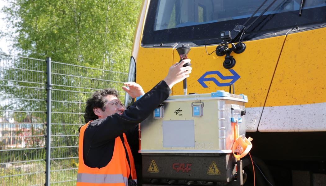 Bildtext: DLR-forskaren Paul Unterhuber kontrollerar det radiobaserade R2DATO-systemet på testbana i Amersfoort. Foto: DLR