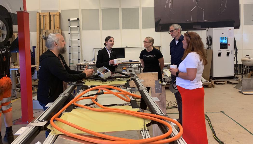 Klimat- och miljöminister Romina Pourmokhtari samtalar med Elonroads grundare Dan Zethraeus och medarbetare i fabriken i Lund. Foto: Elonroad