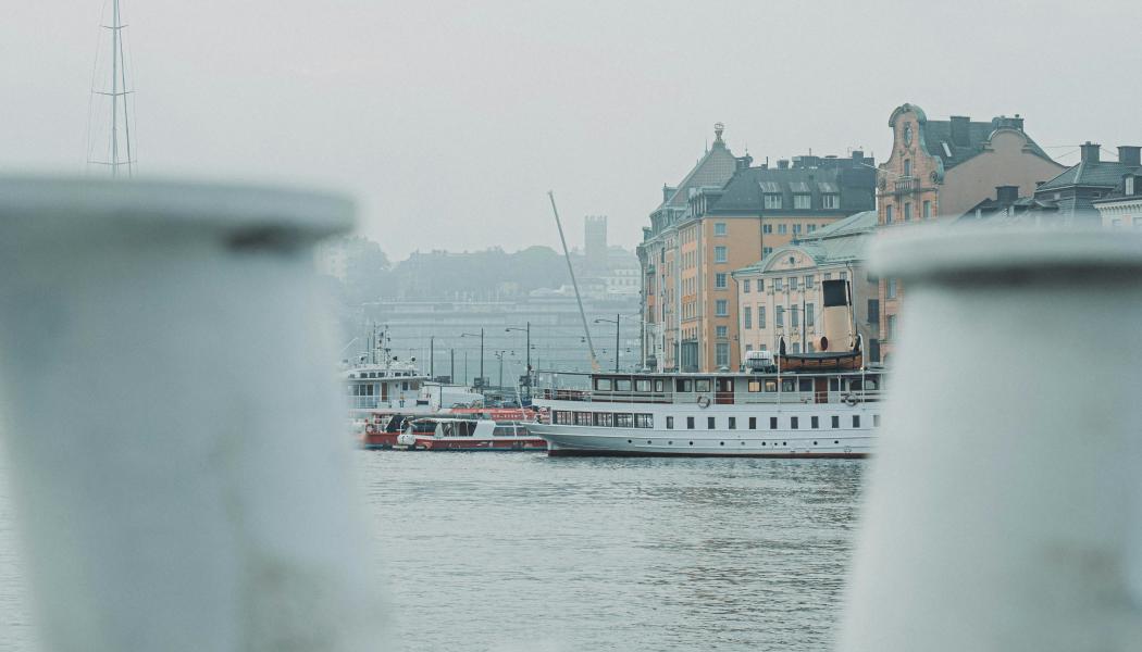 Skeppsbron i Stockholm, sett från vattnet med Gamla stan i bakgrunden. Foto: Magnus Andersson/Unsplash