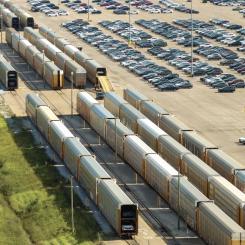 Nya bilar lastas på biltransportvagnar vid bilfabrikens parkeringsplats. Foto: INPS Group